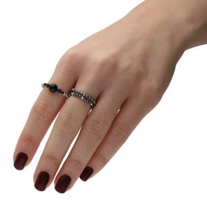 pierścionek elastyczny z hematytem spinelem onyksem założony na palcu z innymi ciemnymi pierścionkami elastycznymi