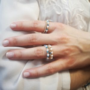 Zestaw pierścionków elastycznych pozłacanych z kuleczkami z masy perłowej i turkusu założone na palce