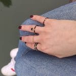 pierścionek elastyczny pozlacany ze spinelem hematytem na palcu razem z innymi pierścionkami elastycznymi