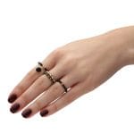 Złoty pierścionek elastyczny z kuleczką złota i czarnym onyksem na palcu razem z innymi pierścionkami