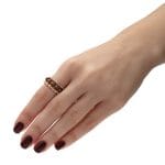 Złoty pierścionek elastyczny goldfilled z granatem na palcu razem z innymi pierścionkami elastycznymi z kuleczek goldfilled