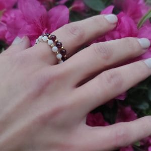 Złoty pierścionek elastyczny goldfilled z granatem na palcu razem z pierścionkiem srebrnym pozłacanym z masą perłową