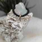 Złoty pierścionek elastyczny z kuleczką złota i czarnym onyksem na akwamarynie