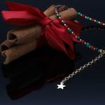 Świąteczna bransoletka damska srebrna pozłacana z naturalnym koralem i malachitem położona przy cynamonie. Bransoletka posiada przedłużkę na której końcu zawieszona jest zawieszka z logo Rosett