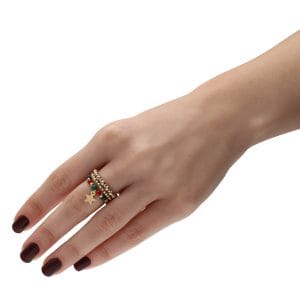 Damski świąteczny pierścionek elastyczny pozłacany z gwiazdką koralem i malachitem, założony na palec z pierścionkami elastycznymi z kuleczek ze srebra pozłacanego